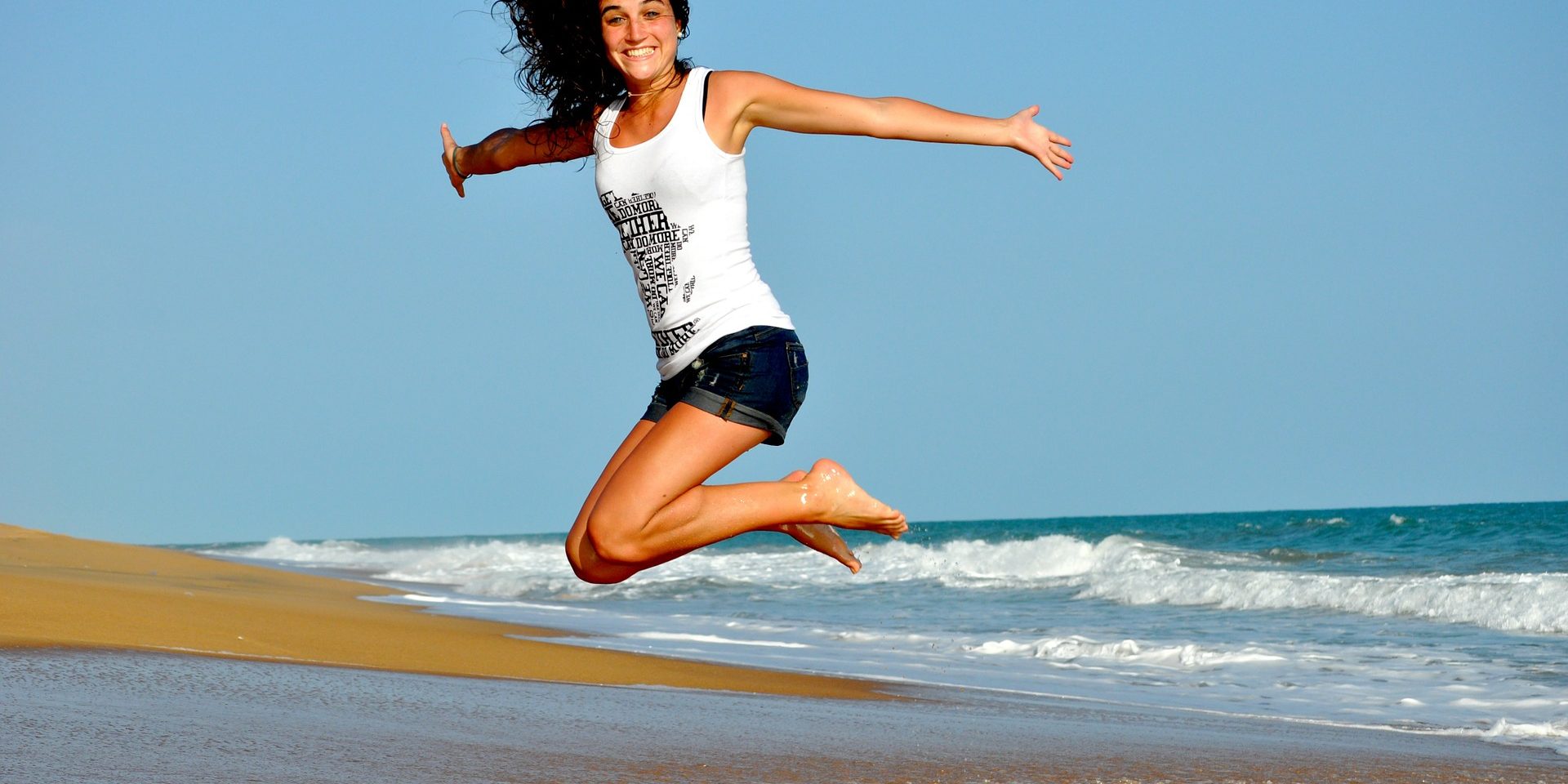 Frau springt in die Luft am Meer