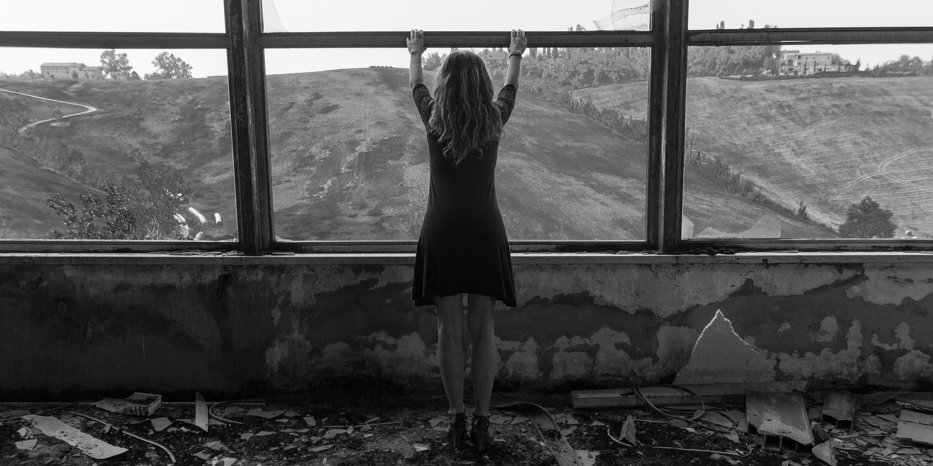 Frau in Ruine macht das Fenster auf